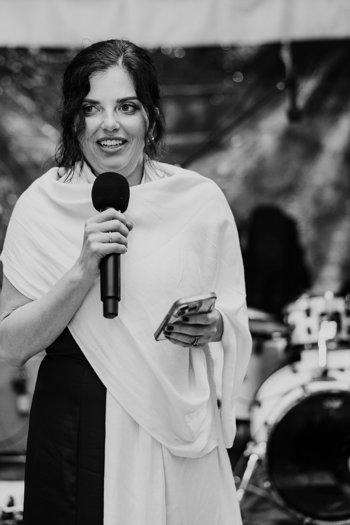 Black and white photo of bride's sister giving speech during wedding reception at Terra Mia Vineyard in Paso Robles, California