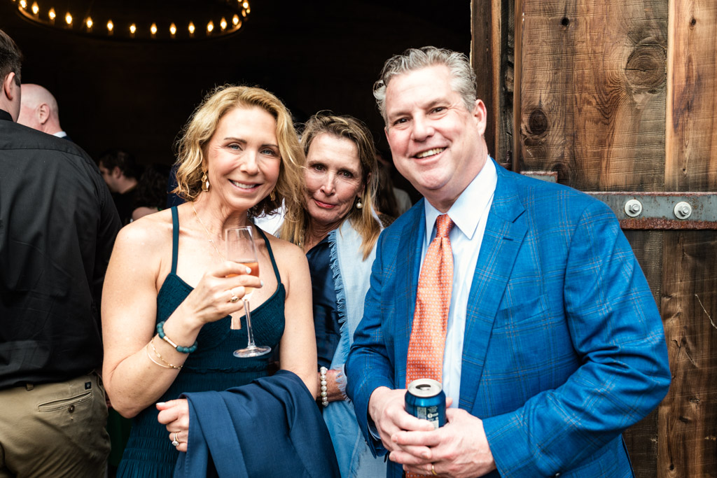 Three guests smiling during cocktail hour at Terra Mia Vineyard wedding reception