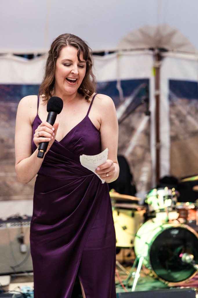 Bridesmaid in a purple dress gives speech during wedding reception at Terra Mia Vineyard in Paso Robles, California