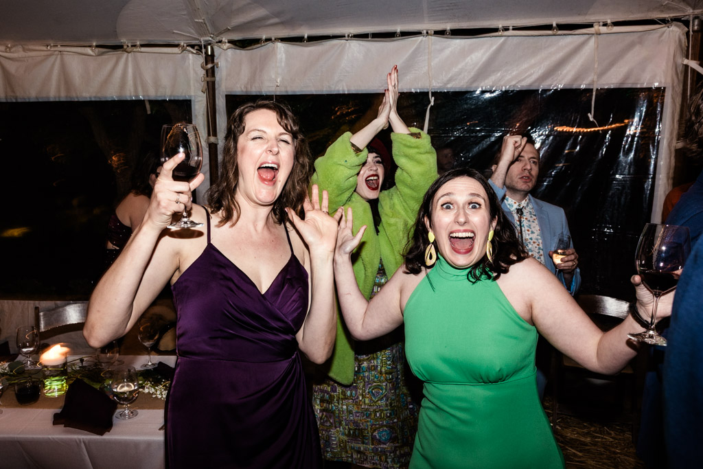 Bridesmaid and guest cheering and holding drinks during wedding reception at Terra Mia Vineyard