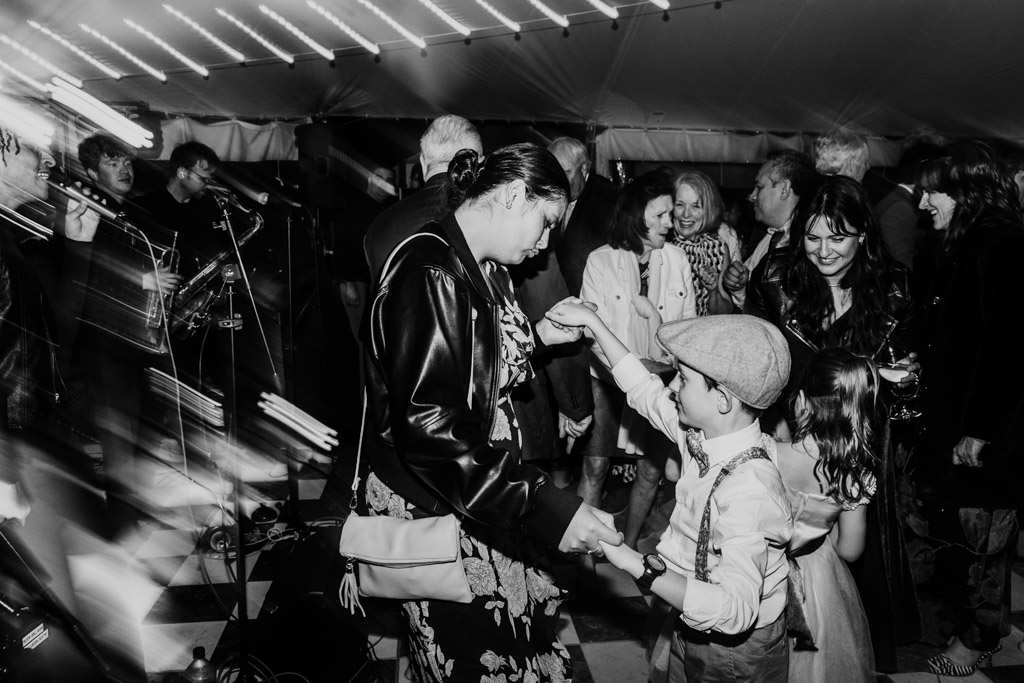 Black and white photo of guests dancing under string lights at Terra Mia Vineyard wedding reception