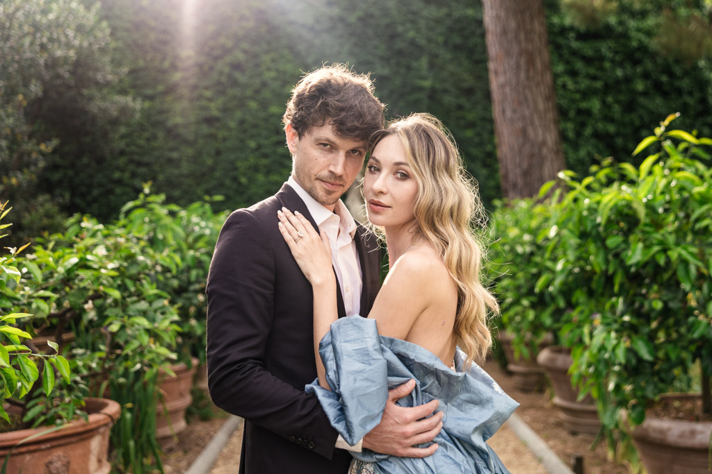 Portrait of couple in Orto Botanico Comunale di Lucca, both looking at the camera with soft sunlight behind them