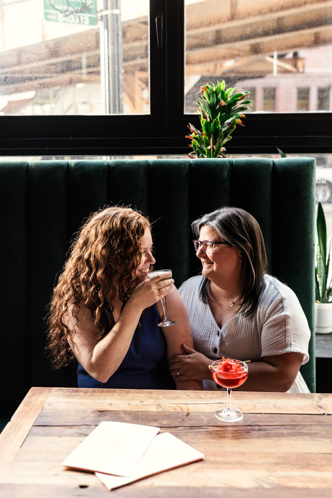 Engaged couple sits together inside Clara cocktail bar in Wicker Park