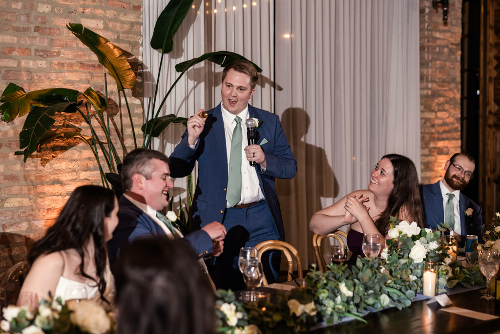 Best Man in a blue suit gives a toast at a wedding reception at The Arbory