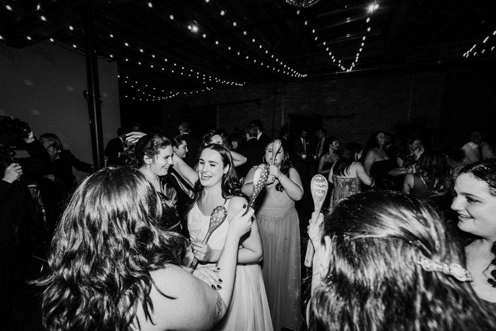Black and white photo of bride and guests on the dance floor during wedding reception at The Arbory