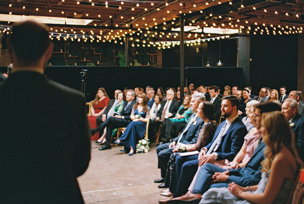 Film photo of guests seated for wedding reception under string lights at The Arbory