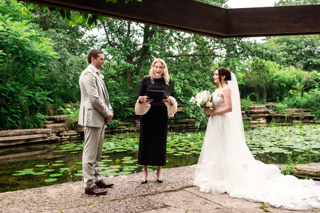 Bride and groom stand with officiant by Alfred Caldwell Lily Pool during their elopement wedding