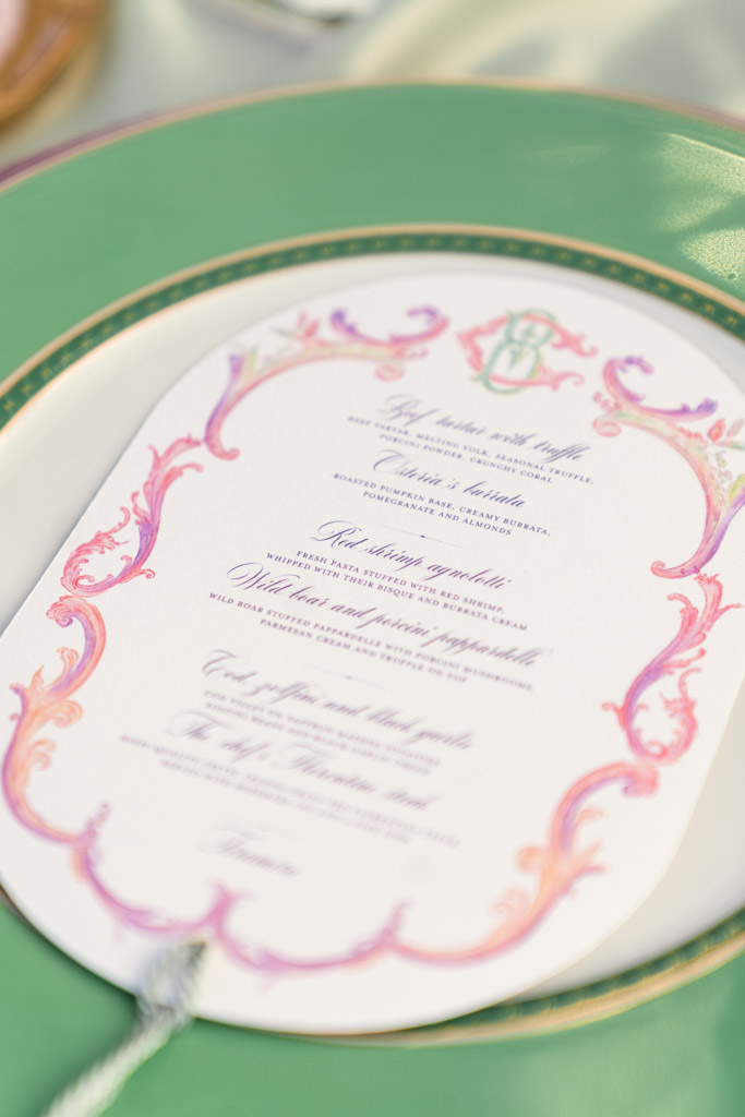 Ornate wedding menu with pink and gold accents on a green and gold plate for an Italian Villa wedding celebration