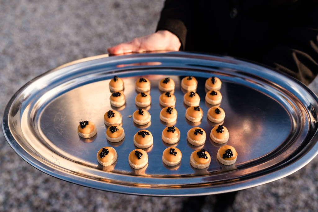Silver tray with small round appetizers topped with black caviar for Italian Villa wedding celebration