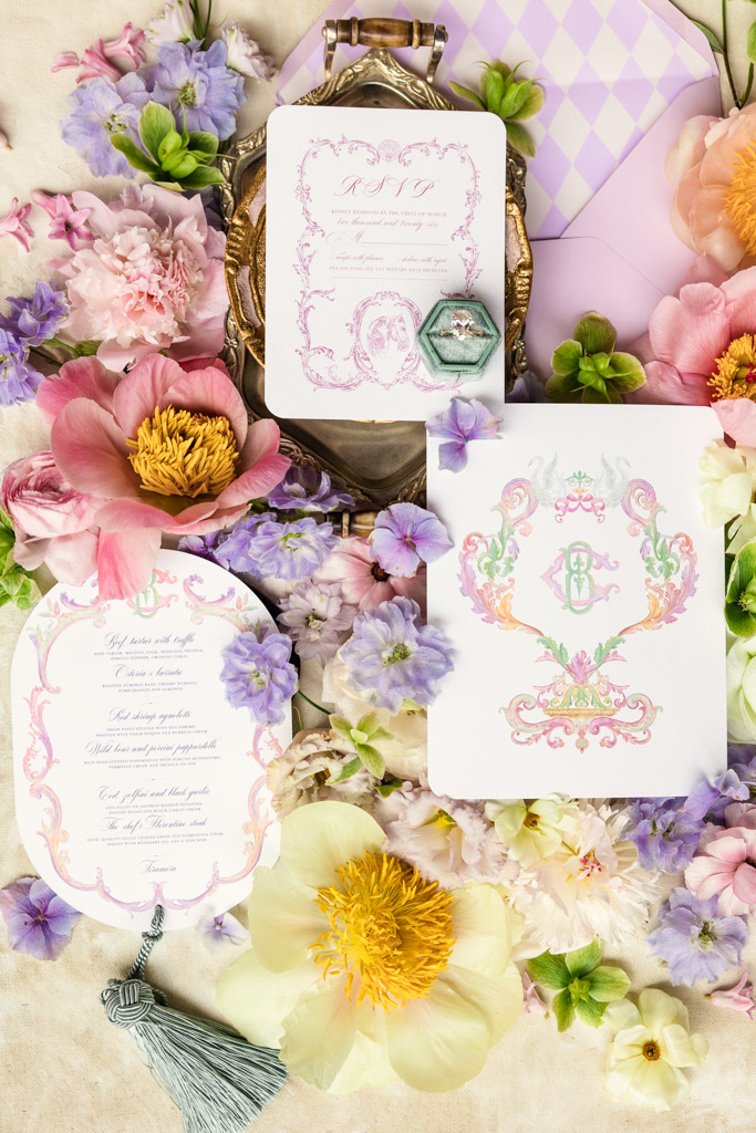 Floral wedding stationery with RSVP card, invitation, and pastel flowers, ring, and envelope arranged decoratively for an Italian Villa wedding
