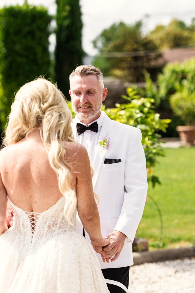 Bride and groom holding hands outdoors at their first look outside an Italian Villa