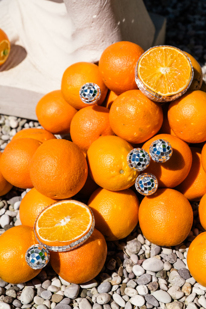 Oranges and lemons with disco ball ornaments on rocks for wedding pool party at Villa Moscheni in Tuscany, Italy