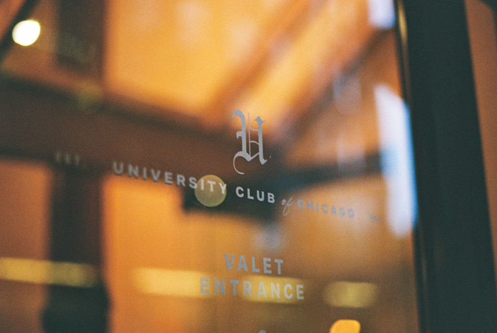 Film photo of glass door featuring the University Club of Chicago logo