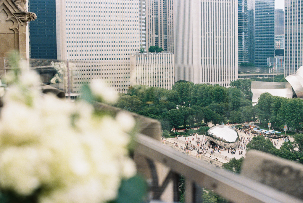 Film photo of Cloud Gate sculpture in Millennium Park, Chicago, with city buildings, taken from a balcony at the University Club of Chicago