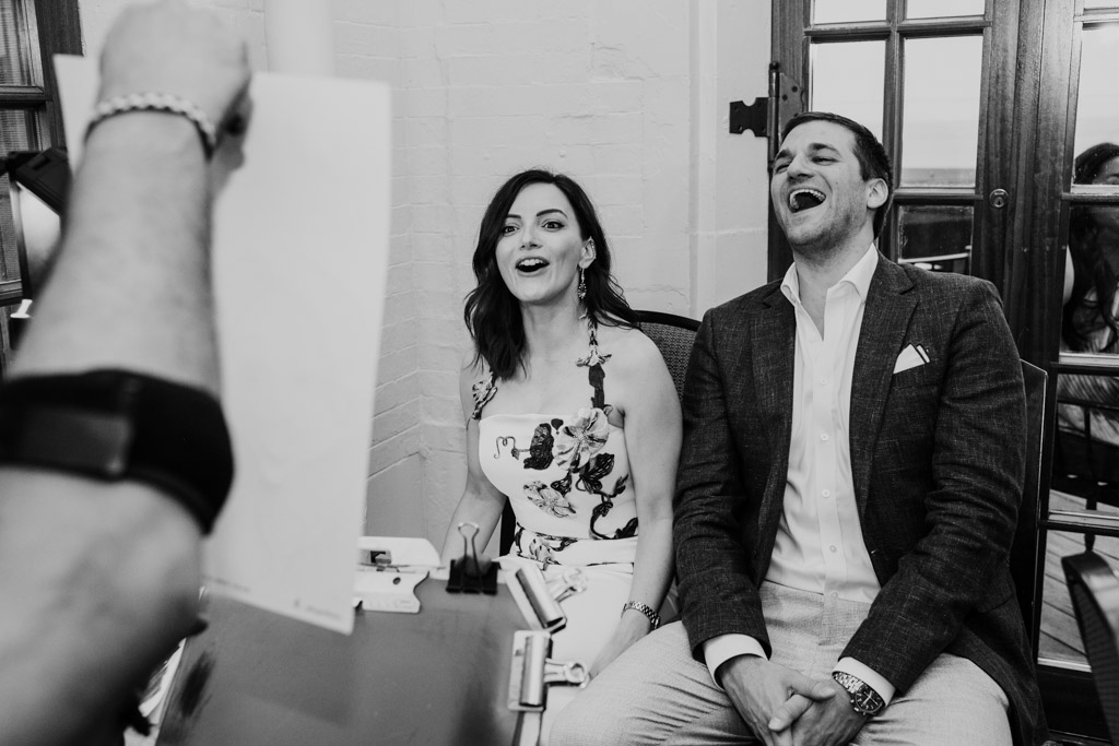 Newlwyeds laugh together at their sketched caricature during their wedding celebration at the University Club of Chicago