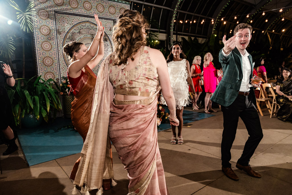 Bride, groom and guests dancing during Indian wedding reception at Garfield Park Conservatory