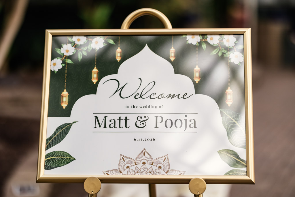 Wedding welcome sign with “Matt & Pooja 6.13.2026,” floral and lantern decorations, gold frame—perfect for your Chicago Indian wedding.