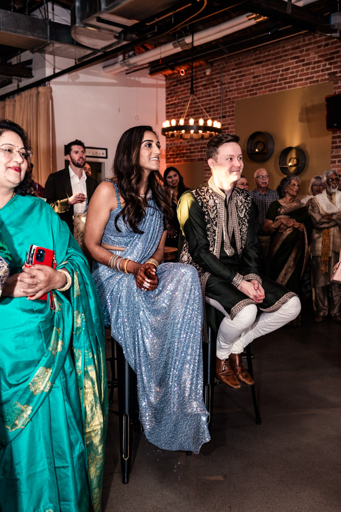 Bride and groom listen to speech during their Sangeet at Ovation Chicago